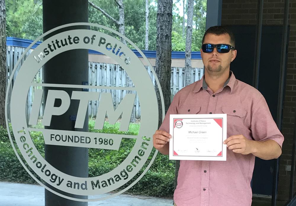 Michael Green holding his certificate from the Institute of Policy Technology and Management
