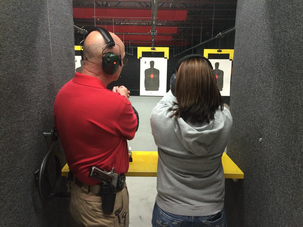 person in a gray shirt being instructed by a person in a red shirt