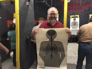 a guy holding his target from shooting at the firearms range