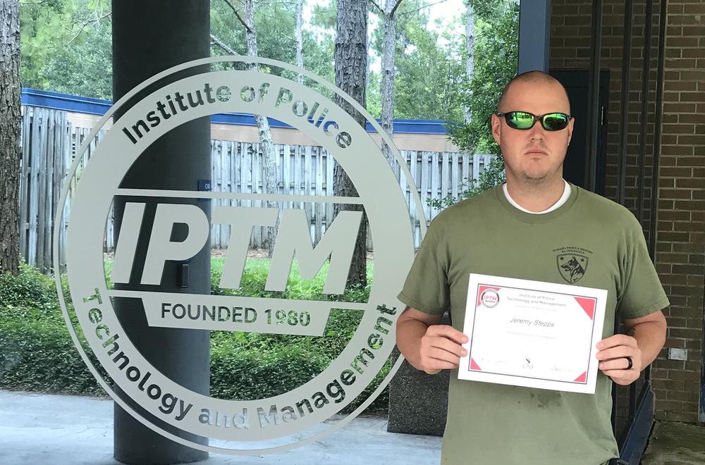 Jeremy Stepps holding his certificate from the Institute of Policy Technology and Management