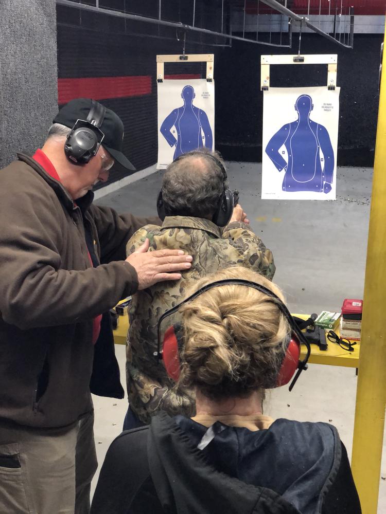 person being instructed on how to use a firearm